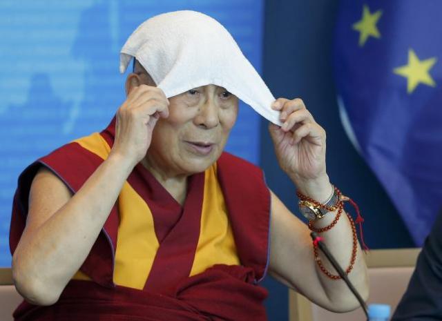 Tibet's exiled spiritual leader the Dalai Lama puts a towel on his head during a visit at the Council of Europe in Strasbourg, France, September 15, 2016. REUTERS/Vincent Kessler
